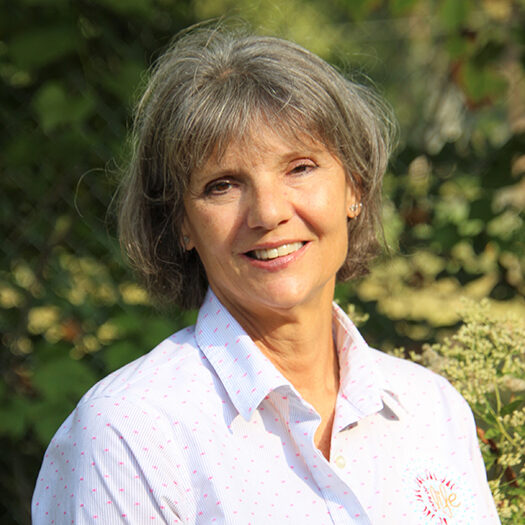 Ms. Kathy, Grant Park Chiropractic advocate, smiling in a white patterned shirt