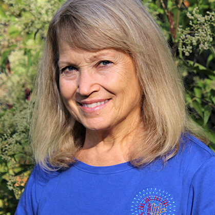 Ms. Laura, Thai bodywork practitioner, smiling in a blue shirt